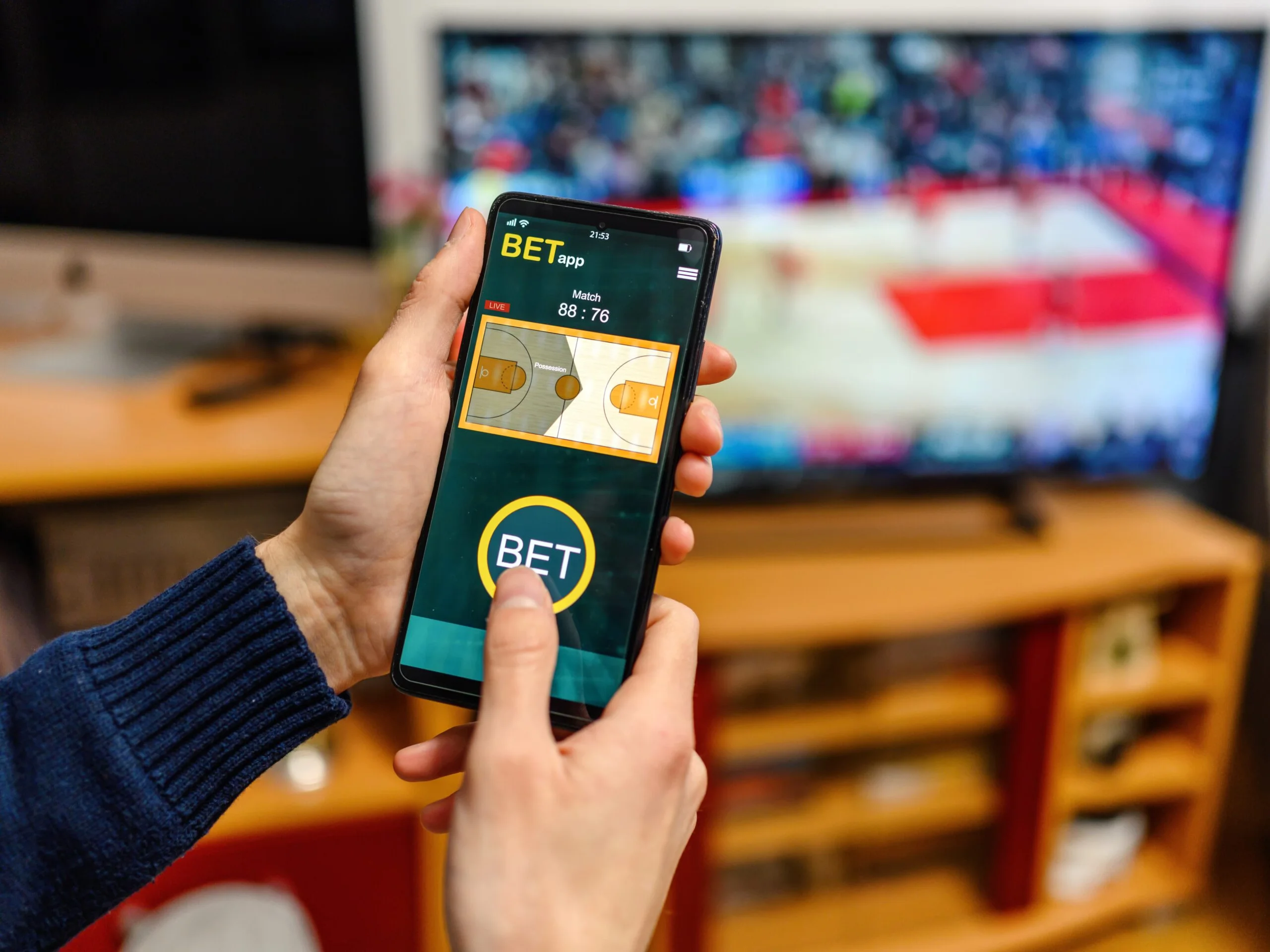 Dedicated BD sports fan checking live match data on multiple screens during a major cricket game